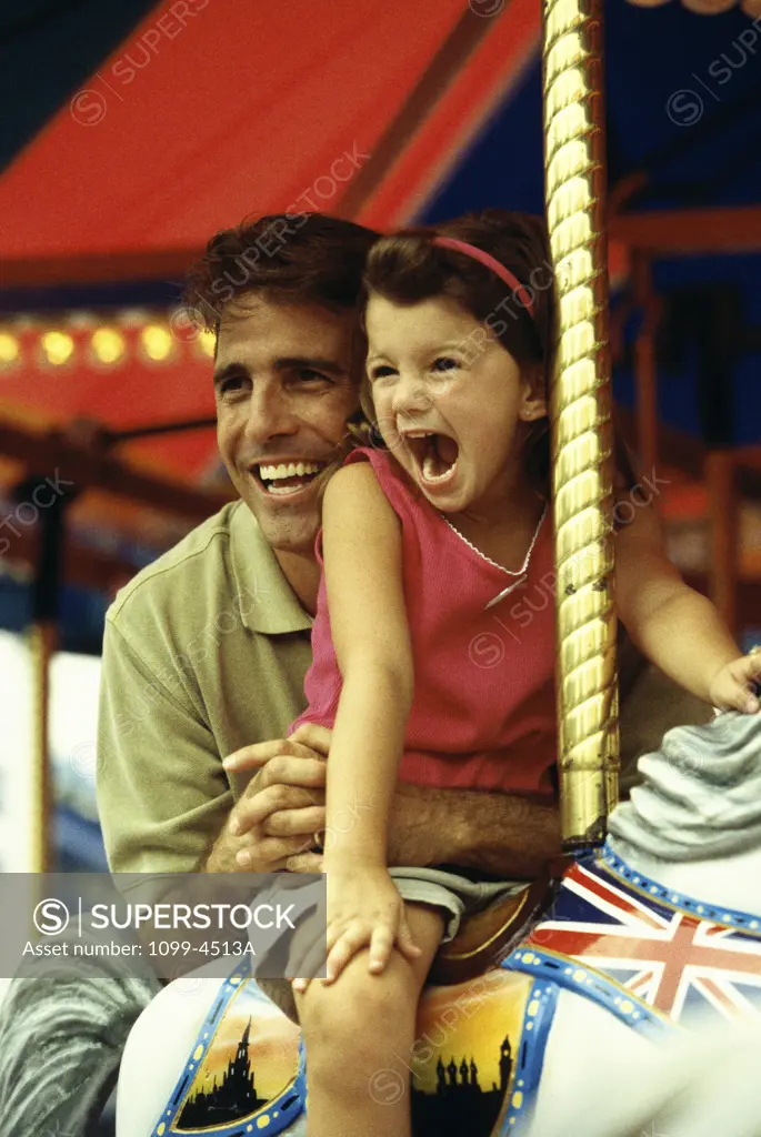 Father and his daughter on a carousel
