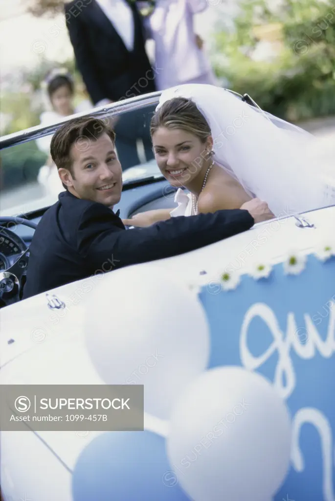 Portrait of a newlywed couple in a convertible car
