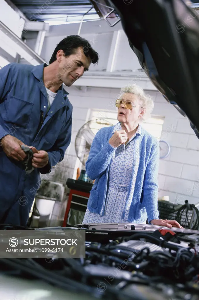 Senior woman standing beside a mechanic