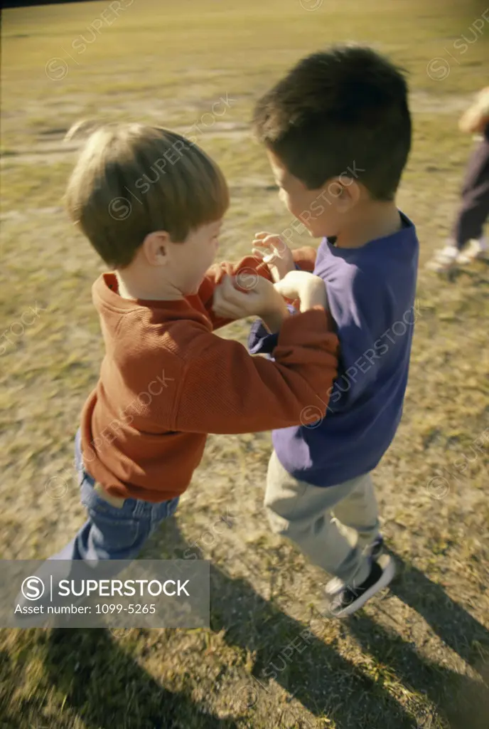 Two boys pushing each other