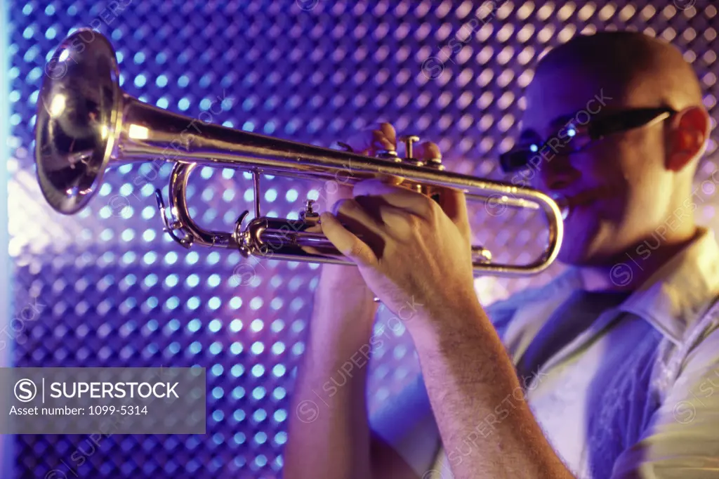 Side profile of a young man playing the trumpet