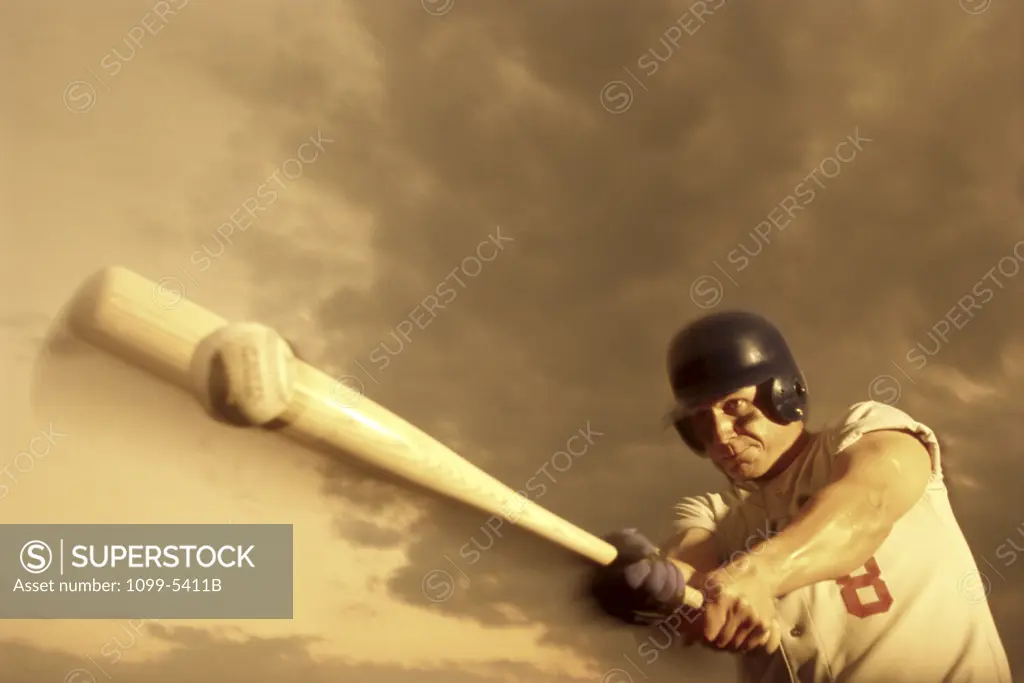 Low angle view of a baseball player swinging a baseball bat