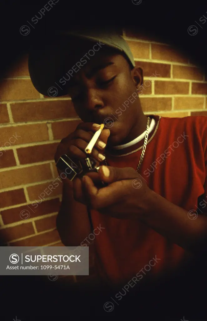 Teenage boy lighting a cigarette