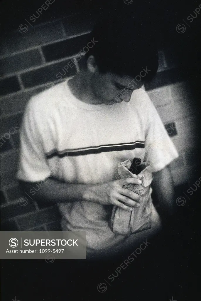 Teenage boy holding a bottle of alcohol