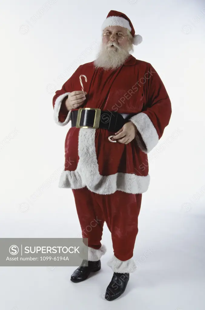 Portrait of Santa Claus holding candy canes