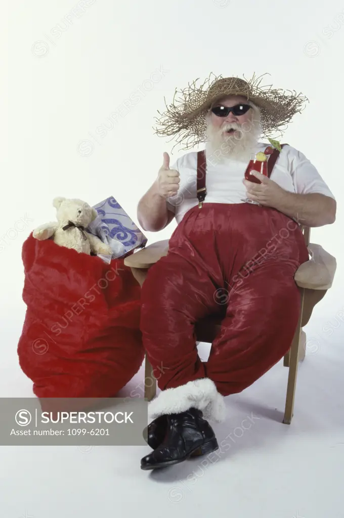 Santa Claus sitting on a chair wearing a straw hat