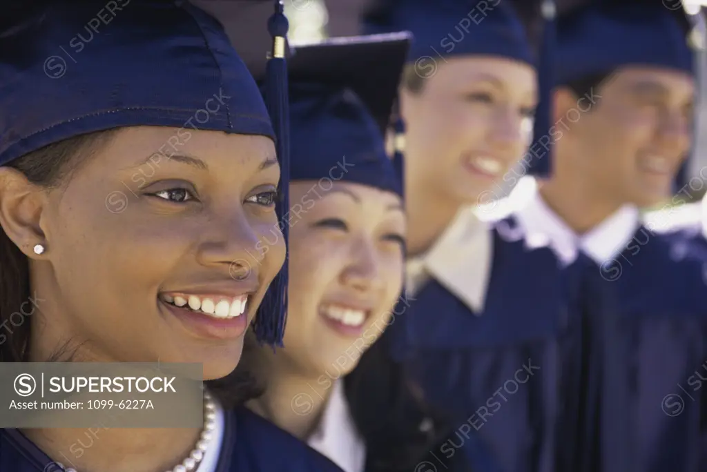 Group of young graduates standing in a row