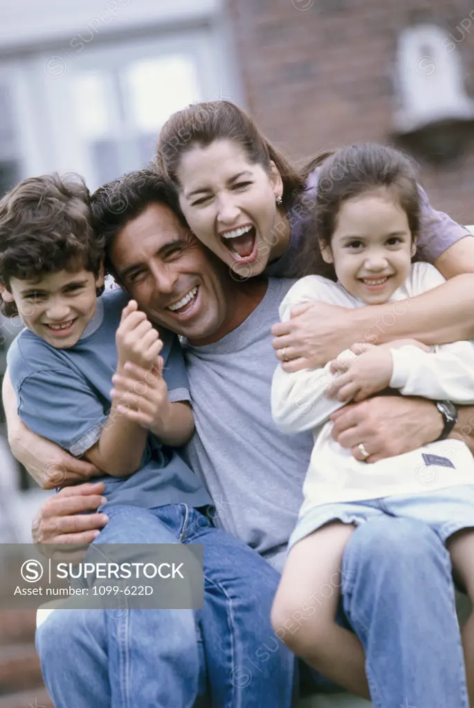 Mid adult couple sitting with their son and daughter smiling