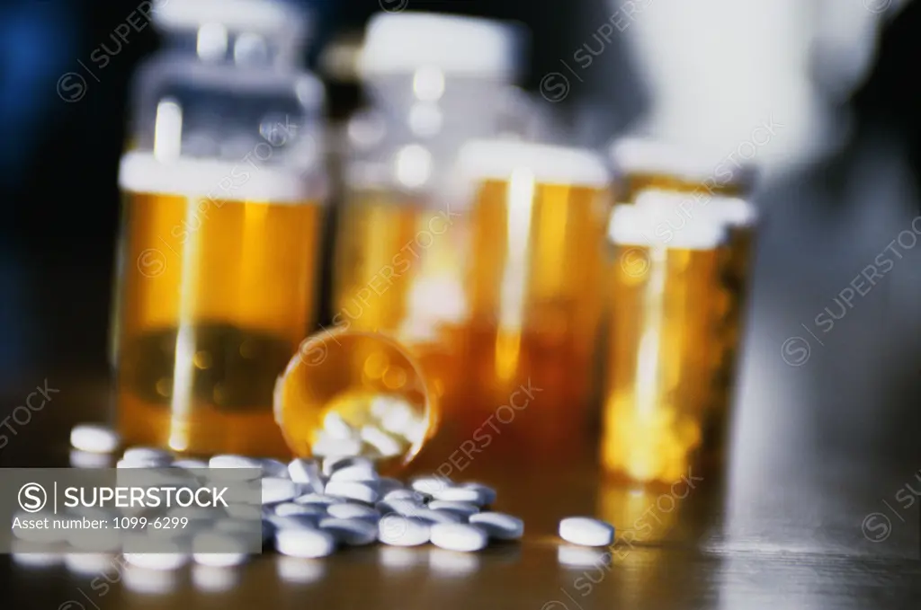 Close-up of a vial of medical pills strewed on a table