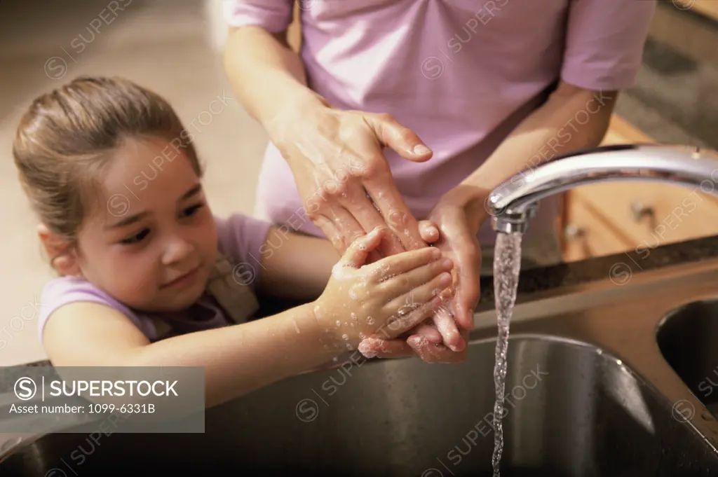 Young girl washing her hands in a wash basin