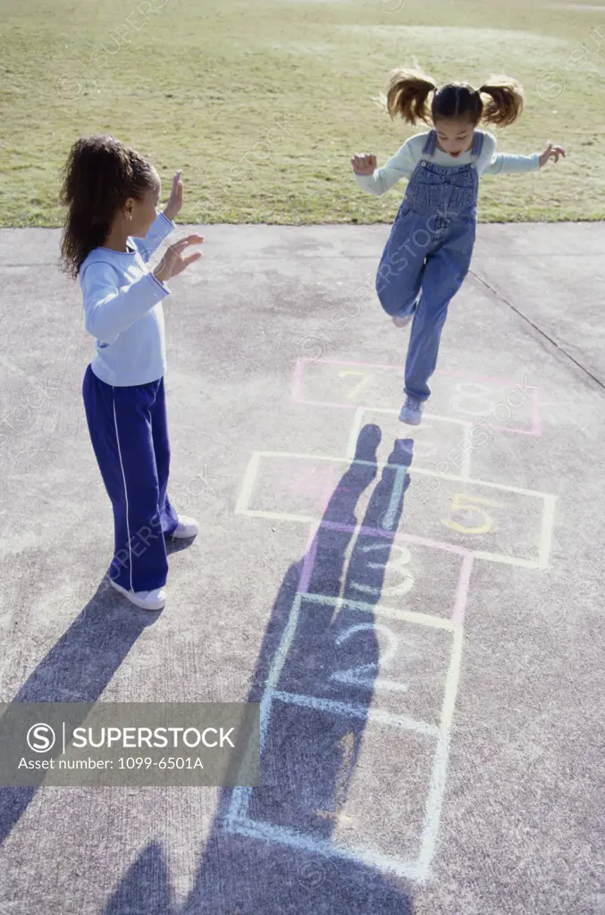 High angle view of two girls playing hopscotch