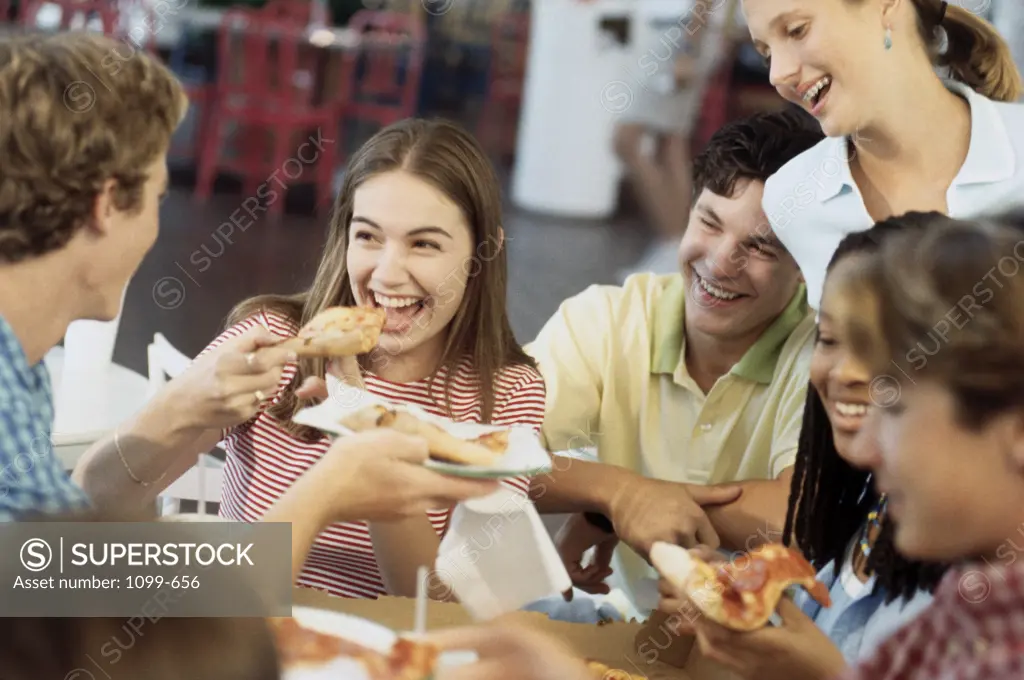 Group of teenagers eating pizza