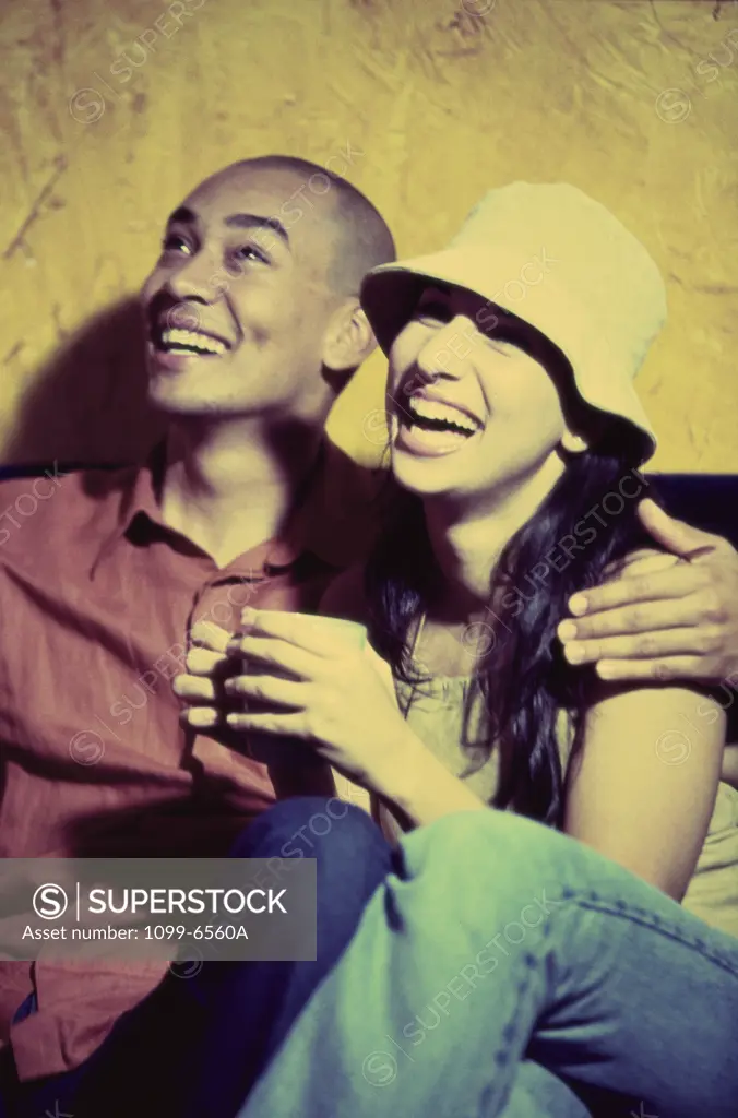Young couple sitting together laughing