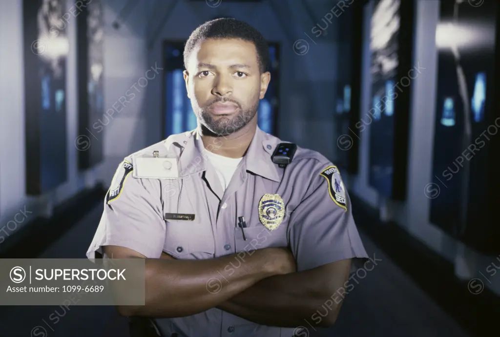Portrait of a male security guard standing with his arms crossed