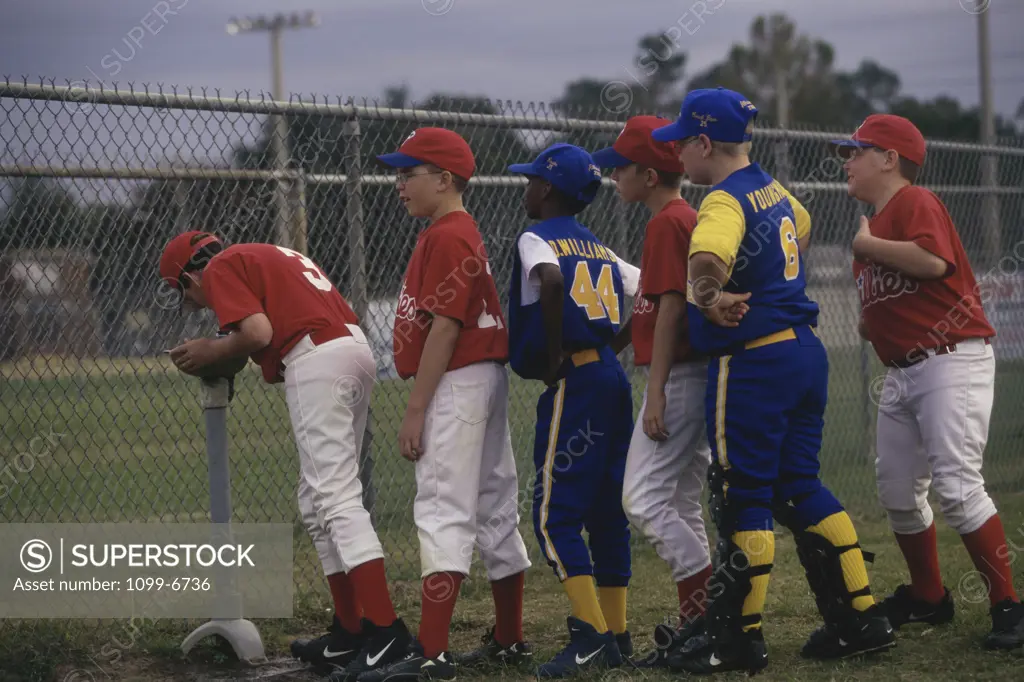 Side profile of a group of boys on a baseball team standing in a row