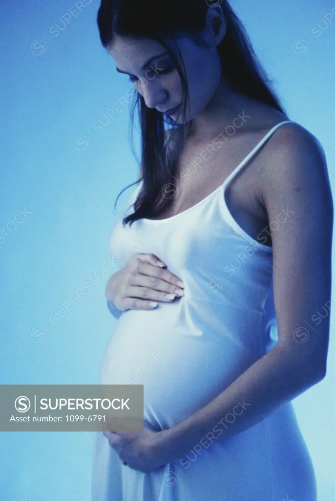 Pregnant teenage girl touching her abdomen