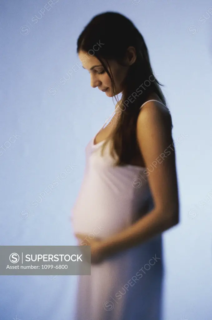 Pregnant teenage girl touching her abdomen
