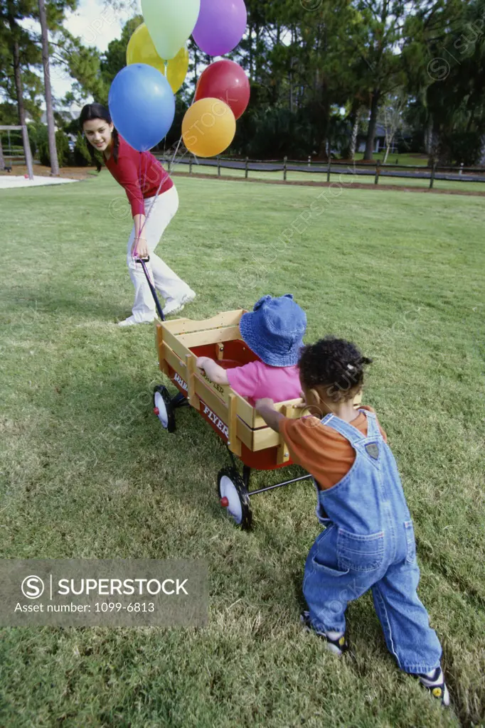 Nanny and a girl pushing a toy wagon