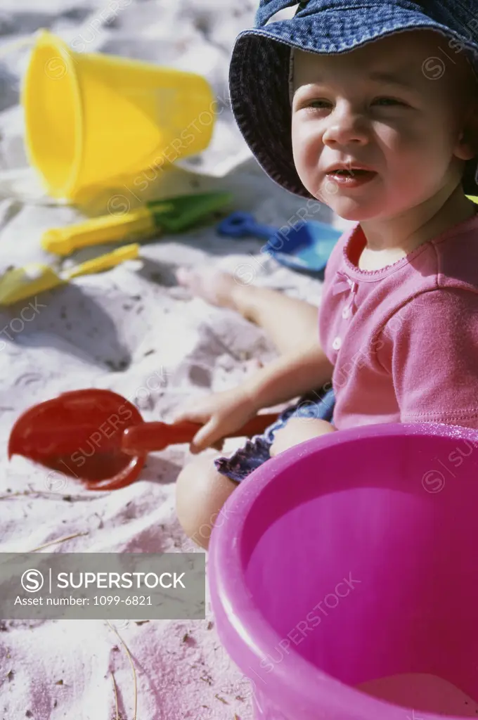 Portrait of a girl playing with a sand pail and a shovel