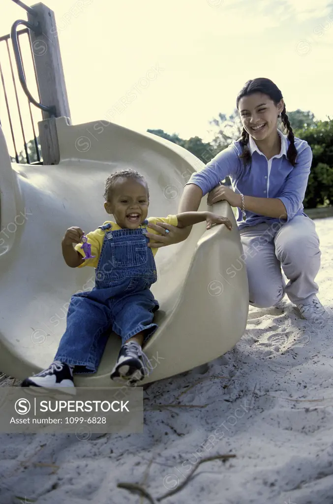 Portrait of a teenage girl playing with a baby boy