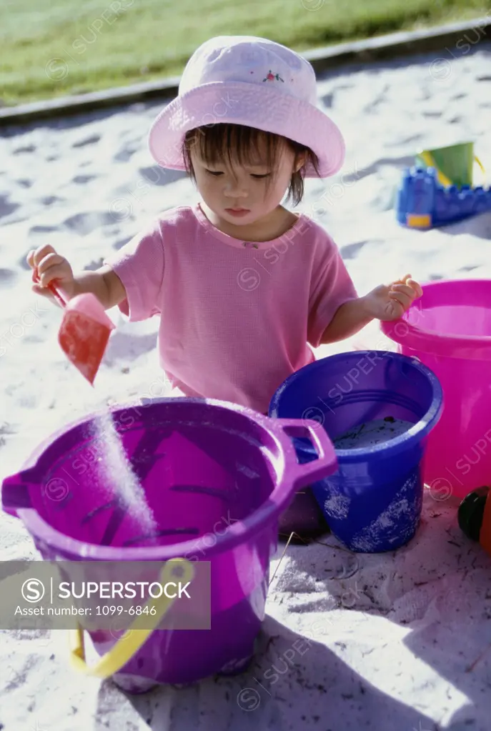 Girl playing with a sand pail and a shovel