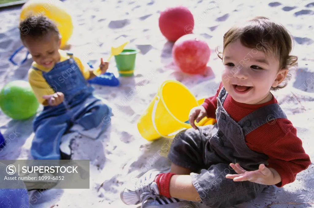High angle view of two boys playing in the sand