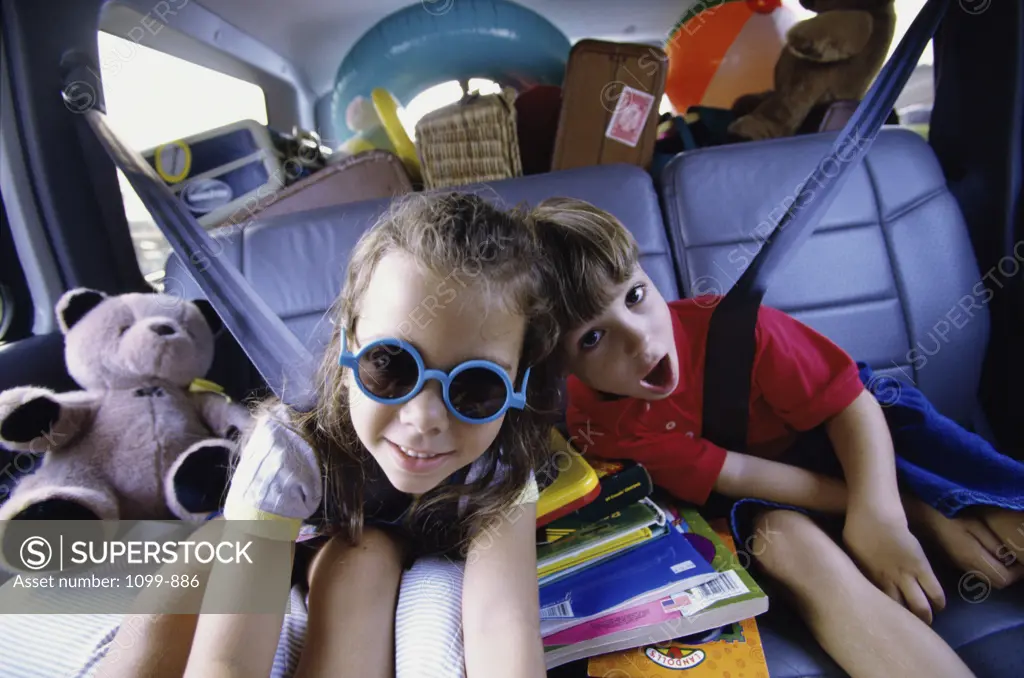 Portrait of a boy and a girl sitting in a car