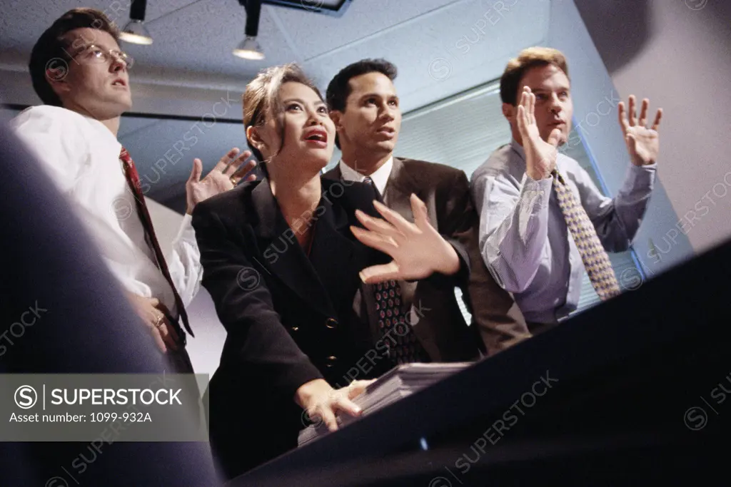 Low angle view of a businesswoman with three businessmen in an office