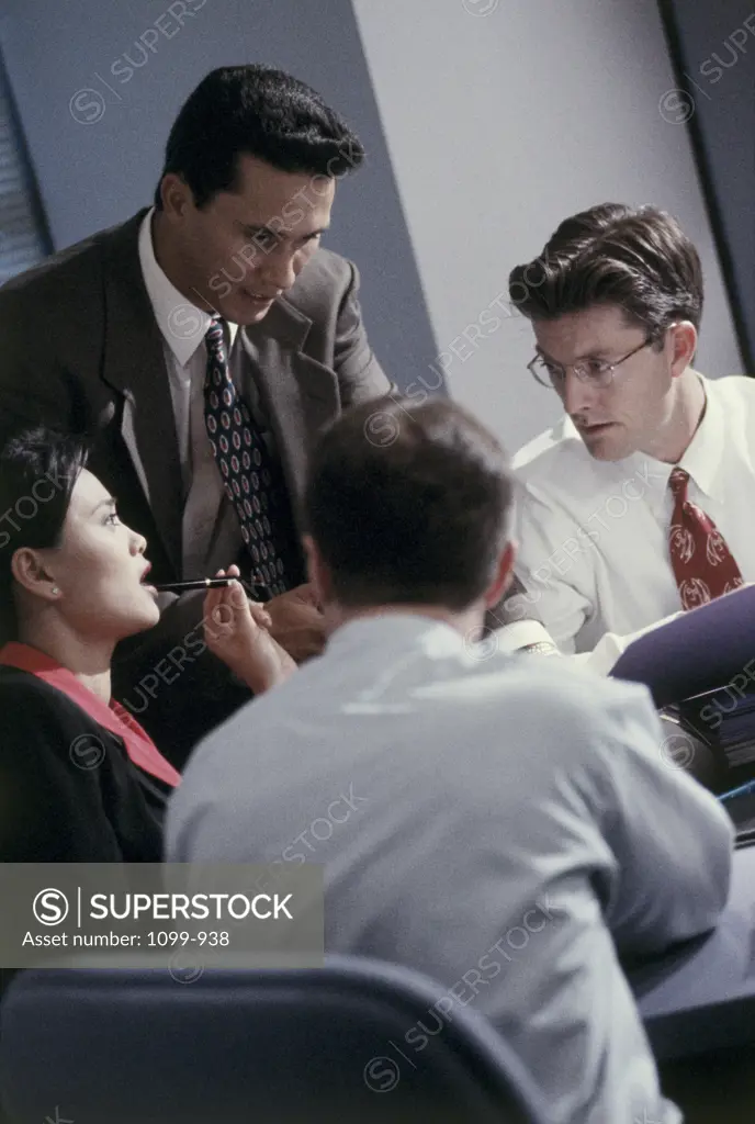Three businessmen and a businesswoman talking in a meeting