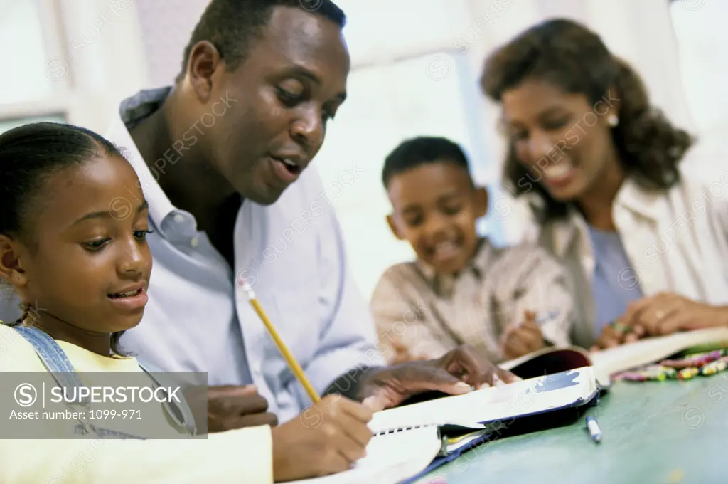 Parents helping their son and daughter with their homework