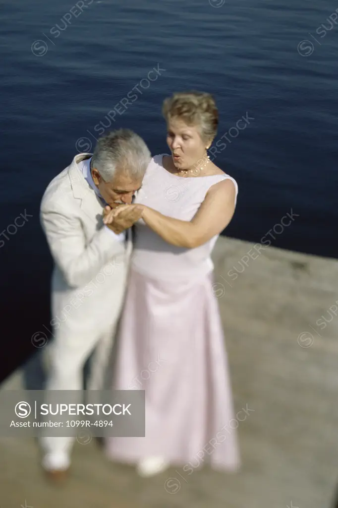 Senior man kissing the hand of a senior woman