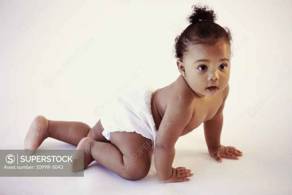 Side profile of a baby girl crawling on the floor