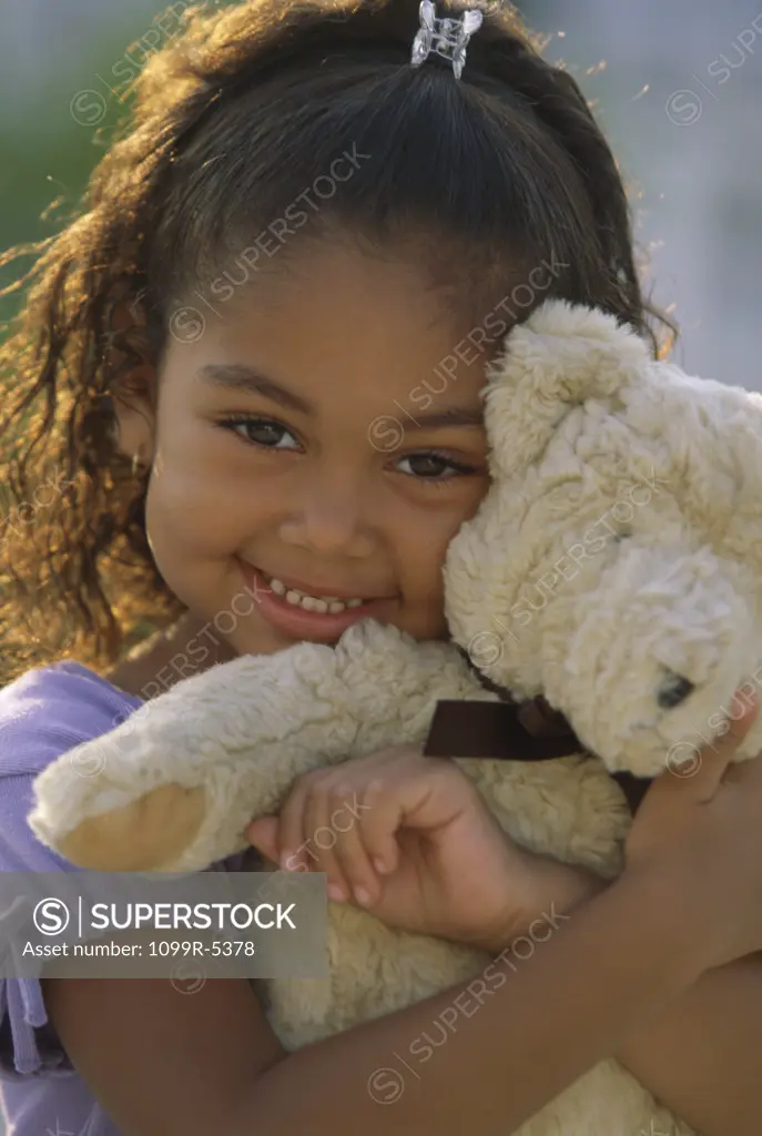 Portrait of a girl holding a teddy bear smiling