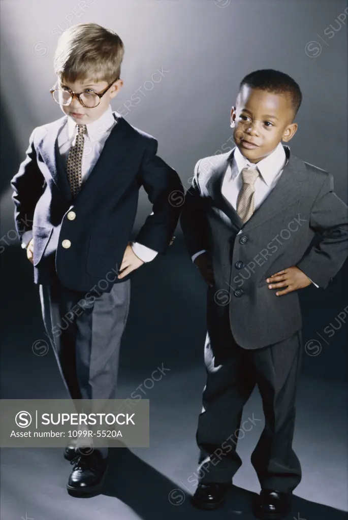 Portrait of two young boys dressed as businessmen