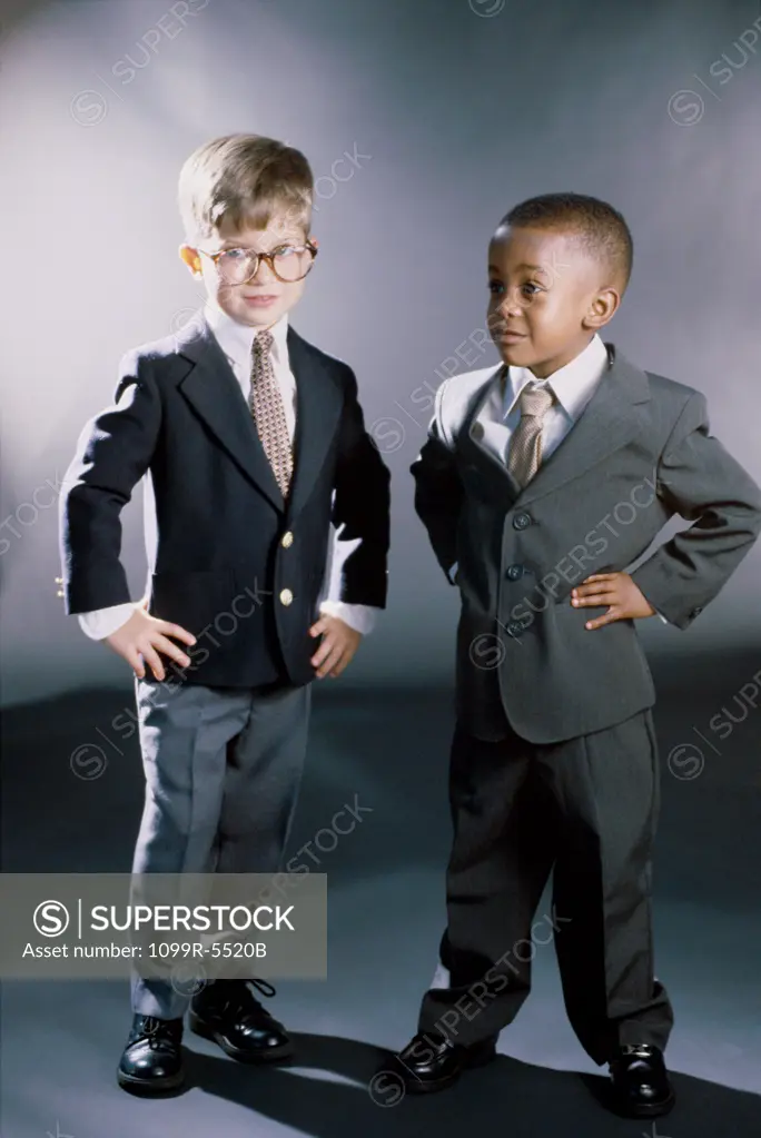 Portrait of two young boys dressed as businessmen