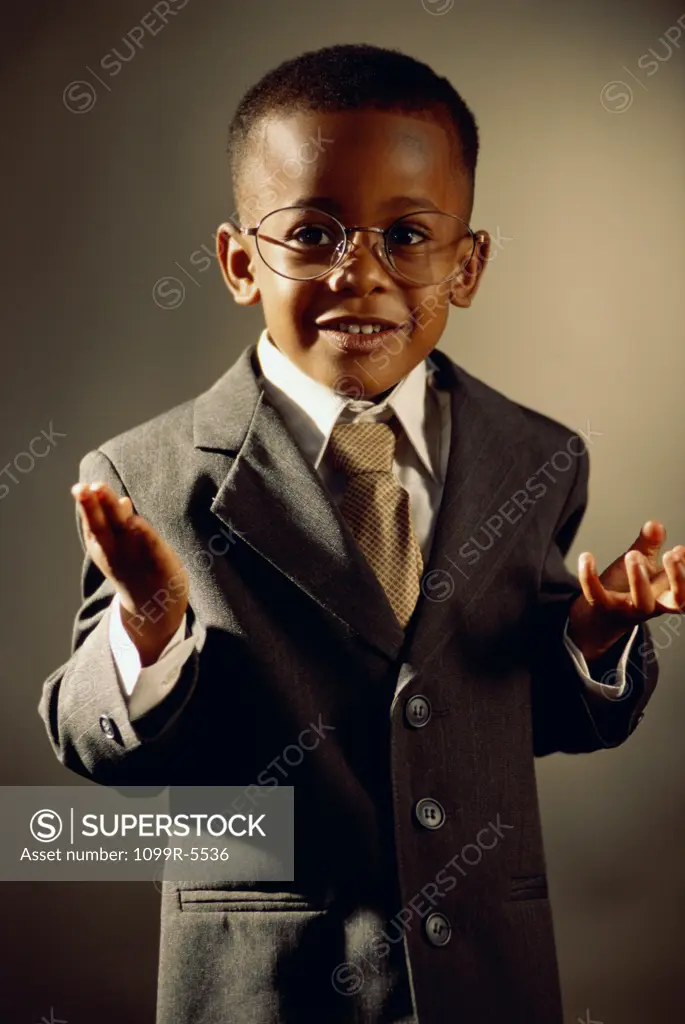 Portrait of a young boy dressed as a businessman gesturing with his hands