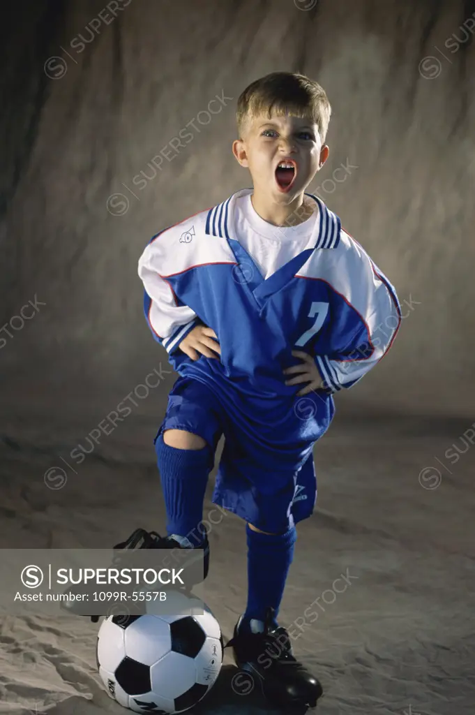 Portrait of a boy standing with his foot on a soccer ball