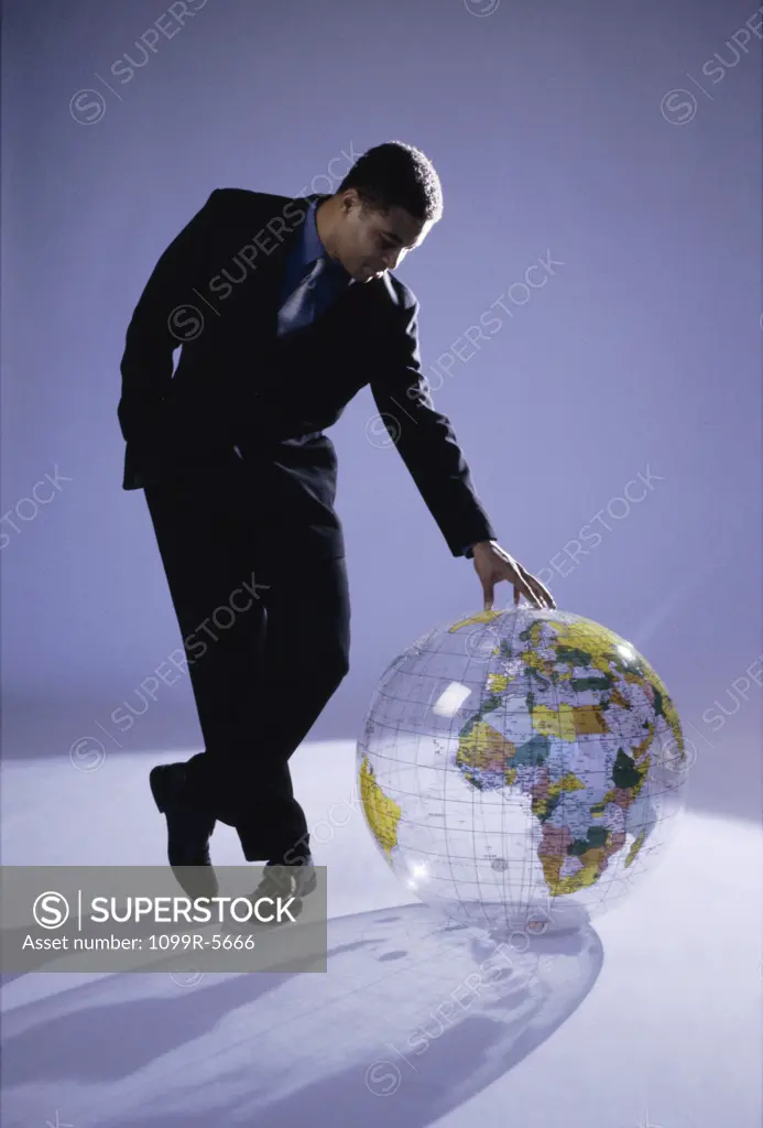 Businessman touching a globe on the floor