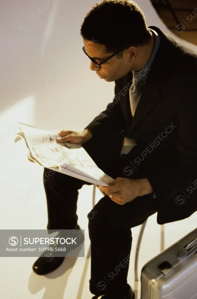 Businessman reading a newspaper sitting on a chair