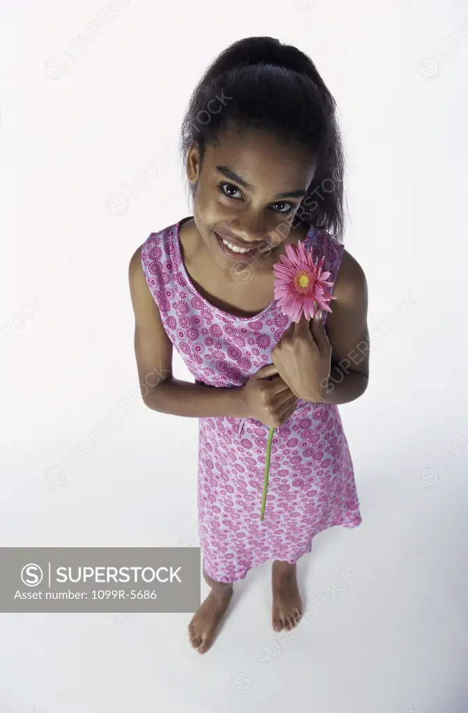 Teenage girl standing holding a flower