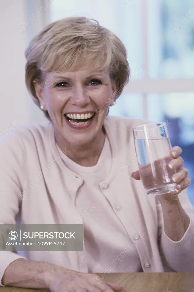 Portrait of an elderly woman holding a glass of water