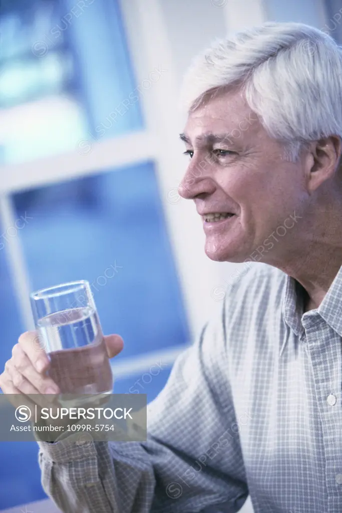 Elderly man holding a glass of water