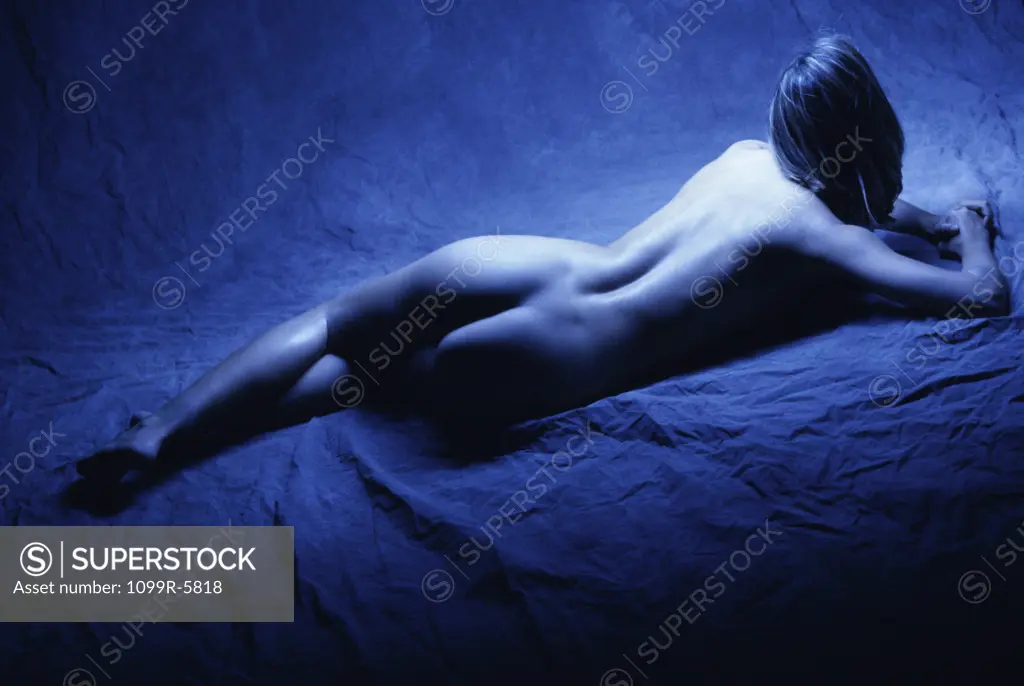 High angle view of a naked young woman lying down