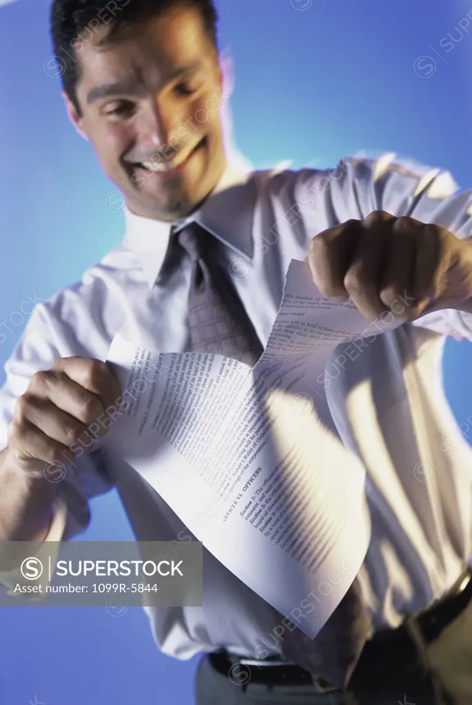 Businessman tearing a sheet of paper
