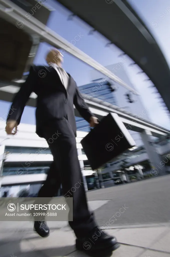 Low angle view of a businessman walking with a briefcase