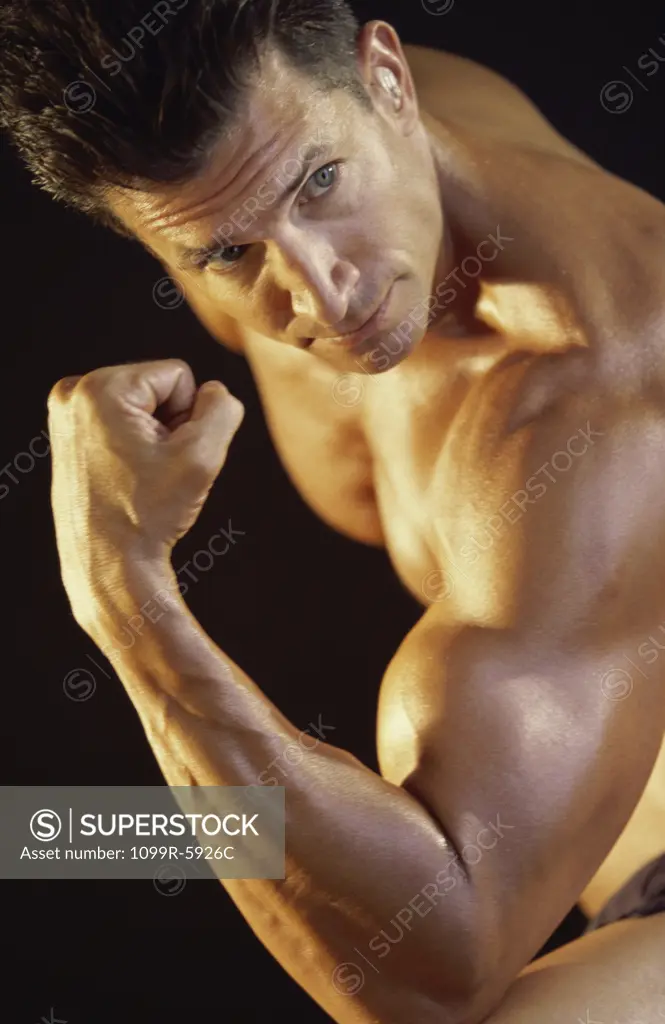 Side profile of a young man flexing his biceps