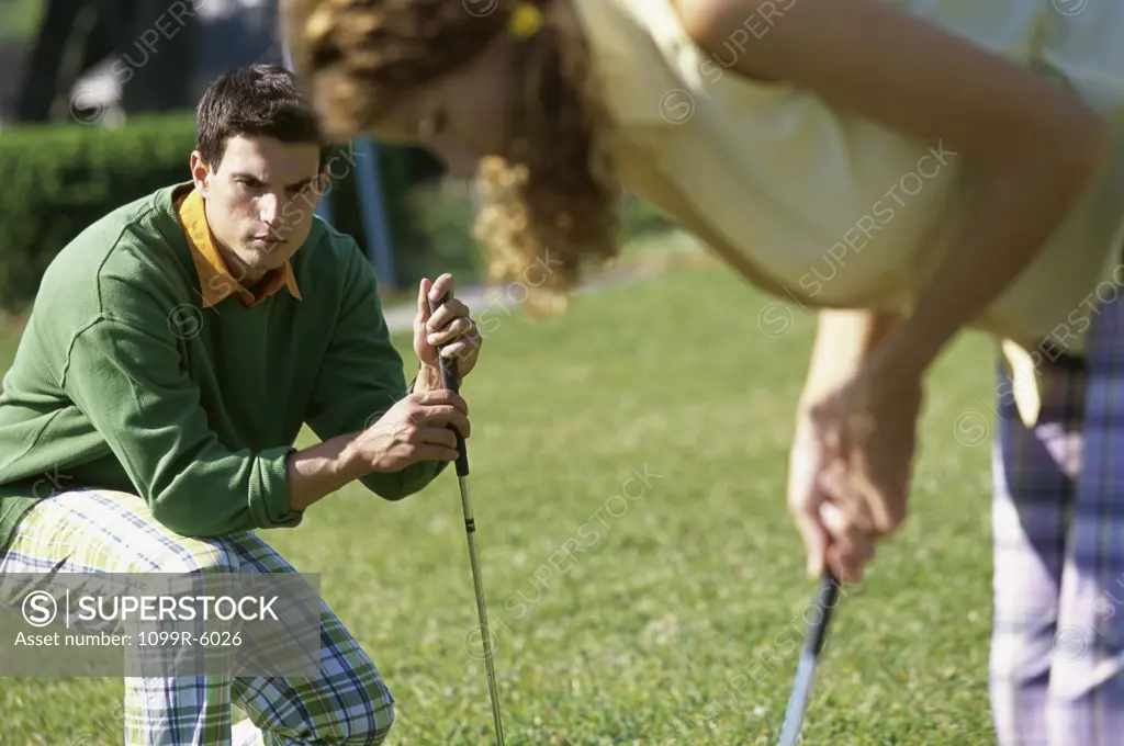 Mid adult man and a mid adult woman playing golf