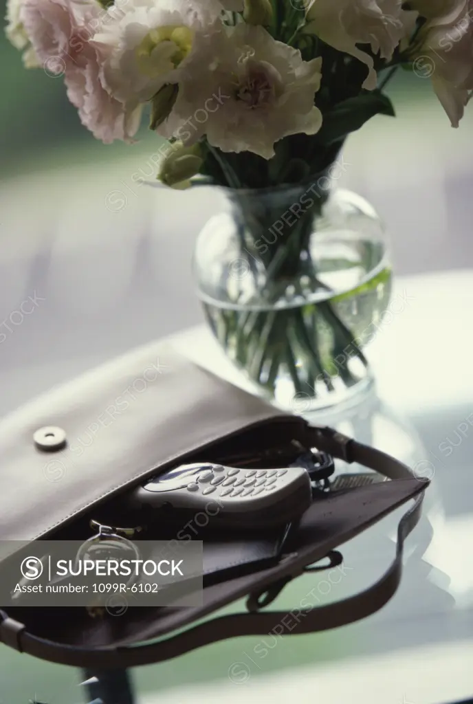 Close-up of a flower vase and a handbag