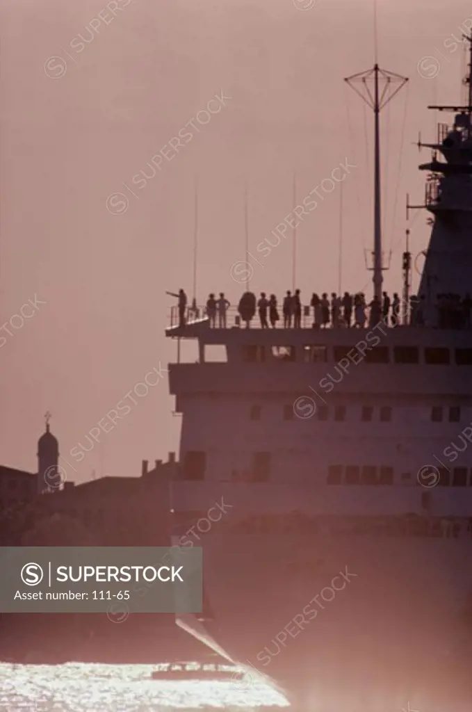Silhouette of a group of tourists standing on a cruise ship