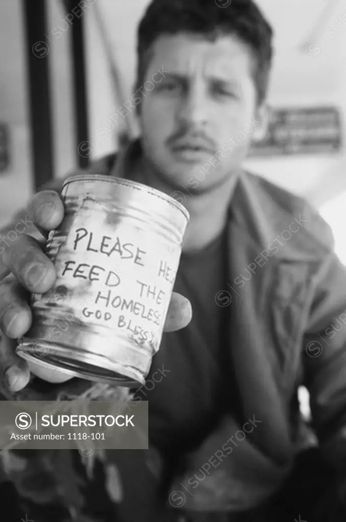 Mid adult man on the street holding a tin can